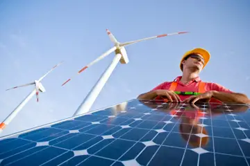 Solpaneler och vindkraftverk och en man
