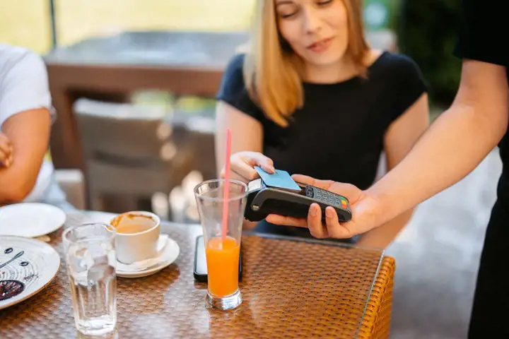 A woman pays a bill at a café